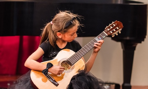 A Suzuki Guitar student performs.